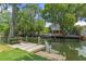 Scenic waterfront view featuring a dock, lush trees, and inviting outdoor seating, perfect for relaxation at 7252 Coventry Ct, Weeki Wachee, FL 34607