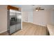 Kitchen with stainless steel refrigerator, wooden cabinets above, light wood floors, and view to the dining room at 7321 Parrot Dr, Port Richey, FL 34668