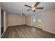 Living room boasts light wood floors, sliding glass door to the backyard, and a ceiling fan at 7321 Parrot Dr, Port Richey, FL 34668