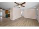 Open-concept living room with wood-look floors, ceiling fan, and seamless transition to kitchen and dining area at 7321 Parrot Dr, Port Richey, FL 34668