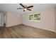 Bright living room features a ceiling fan, wood-look flooring, and a large window, creating a welcoming atmosphere at 7321 Parrot Dr, Port Richey, FL 34668