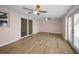 Living room with light wood floors, two ceiling fans, and sliding glass door to the backyard at 7321 Parrot Dr, Port Richey, FL 34668