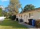Exterior shot of the back of the house, a green yard and mature trees at 7508 Cypress Knee Dr, Hudson, FL 34667