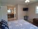 Bright bedroom with a large bed, shuttered windows, and an ensuite bathroom view at 7508 Cypress Knee Dr, Hudson, FL 34667