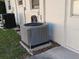 A modern air conditioning unit on a concrete base, near a building wall and greenery at 7508 Cypress Knee Dr, Hudson, FL 34667