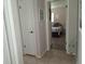 Hallway with tan flooring leading to a bedroom decorated with a nautical theme at 7508 Cypress Knee Dr, Hudson, FL 34667