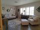 Comfortable living room with neutral colors, a large sofa, an armchair, and a floral rug at 7508 Cypress Knee Dr, Hudson, FL 34667