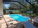 Inviting screened-in pool area with clear blue water, lounge chairs, and lush greenery at 7508 Cypress Knee Dr, Hudson, FL 34667