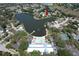 Aerial view of community with lake, community pool, tennis courts and recreational facilities at 8340 Divot Way, Port Richey, FL 34668