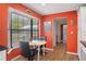 Bright dining area with orange accent wall, modern table, and a large window at 8493 Belmont Rd, Spring Hill, FL 34606