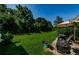 Enjoy a peaceful patio with an umbrella, grill, and lush green space in this backyard setting at 8604 Corinthian Way, New Port Richey, FL 34654