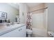 Bathroom with a floral shower curtain, and vanity with a sink and mirror at 8604 Corinthian Way, New Port Richey, FL 34654