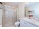 Bright bathroom featuring a glass-enclosed shower, toilet, and vanity with sink at 8604 Corinthian Way, New Port Richey, FL 34654