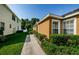 Side view of tan stucco home with manicured landscaping and walkways at 8604 Corinthian Way, New Port Richey, FL 34654