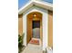 Close-up of front door with welcome mat and sidelight window at 8604 Corinthian Way, New Port Richey, FL 34654