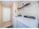 Functional laundry room featuring a washer, dryer, and storage shelf at 8604 Corinthian Way, New Port Richey, FL 34654