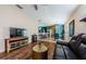 Inviting living room featuring wood floors, leather sofa, and seamless flow to the dining area at 8604 Corinthian Way, New Port Richey, FL 34654