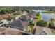 Aerial view of a beautiful residential community, showcasing well-kept homes, lush greenery, and a serene lake at 8635 Creedmoor Ln, New Port Richey, FL 34654