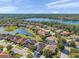 An aerial view of a residential neighborhood showcasing scenic lake views and lush green surroundings at 8635 Creedmoor Ln, New Port Richey, FL 34654