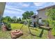 Expansive backyard with a playground, seating area, and lush landscaping, perfect for outdoor enjoyment at 8635 Creedmoor Ln, New Port Richey, FL 34654