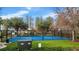 Basketball court and playground area surrounded by mature trees and green grass and an electrical box at 8635 Creedmoor Ln, New Port Richey, FL 34654
