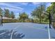 Outdoor blue basketball court with fencing and mature trees surrounding the play area on a partly cloudy day at 8635 Creedmoor Ln, New Port Richey, FL 34654