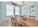 Bright dining room with modern chandelier, and two large windows at 8635 Creedmoor Ln, New Port Richey, FL 34654