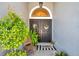 Inviting double front doors with decorative wreaths, foliage, and a welcome mat at 8635 Creedmoor Ln, New Port Richey, FL 34654