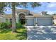 Charming single-story home featuring a well-manicured lawn, mature trees and a two car garage at 8635 Creedmoor Ln, New Port Richey, FL 34654