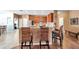 Open kitchen with bar seating featuring stainless appliances, wooden cabinets, and bar with brick accents at 8635 Creedmoor Ln, New Port Richey, FL 34654