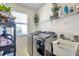 A bright laundry room with modern front-loading machines and storage space at 8635 Creedmoor Ln, New Port Richey, FL 34654