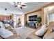 Spacious living room with a large sectional sofa, decorative ceiling fan, and mounted TV at 8635 Creedmoor Ln, New Port Richey, FL 34654