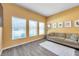Comfortable living room with three large windows, wood-look flooring, and modern decor at 8635 Creedmoor Ln, New Port Richey, FL 34654