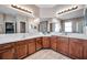 Elegant main bathroom with dual sinks, tile flooring, wood cabinets and large mirrors at 8635 Creedmoor Ln, New Port Richey, FL 34654