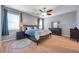 Beautifully lit main bedroom with natural light, a ceiling fan, a dark wood dresser, and light wood flooring at 8635 Creedmoor Ln, New Port Richey, FL 34654