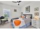 Bright bedroom featuring a ceiling fan, white walls, and a patterned bedspread at 8945 Bella Vita Cir, Land O Lakes, FL 34637