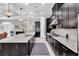 Gourmet kitchen boasts granite countertops, tiled backsplash, stainless appliances, and ample dark wood cabinetry at 8945 Bella Vita Cir, Land O Lakes, FL 34637