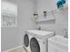 Functional laundry room features modern washer and dryer units with large sink at 8945 Bella Vita Cir, Land O Lakes, FL 34637
