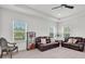 Spacious living room with plush leather sofas, natural light, and recessed ceiling at 8945 Bella Vita Cir, Land O Lakes, FL 34637