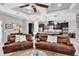 Bright living room with open kitchen view, featuring leather seating and stylish decor at 8945 Bella Vita Cir, Land O Lakes, FL 34637
