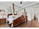 This main bedroom suite boasts a four-poster bed, hardwood floors, tray ceiling, and warm lighting at 8945 Bella Vita Cir, Land O Lakes, FL 34637