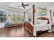 Spacious main bedroom features a four-poster bed, hardwood floors, tray ceiling, and ample natural light at 8945 Bella Vita Cir, Land O Lakes, FL 34637