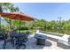 Back patio overlooking beautiful lake featuring outdoor seating, a fire pit, and an umbrella at 8945 Bella Vita Cir, Land O Lakes, FL 34637