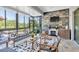 Bright sunroom with cozy seating area, fireplace, and tranquil views of the lake at 8945 Bella Vita Cir, Land O Lakes, FL 34637
