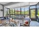 Bright sunroom with cozy seating area, and tranquil views of the lake at 8945 Bella Vita Cir, Land O Lakes, FL 34637