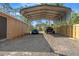 Carport with parked blue Mustang and UTV, offering ample shaded parking and storage for vehicles and equipment at 9078 Birmingham Ave, Weeki Wachee, FL 34613