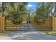 Ornate metal gate featuring deer motifs, securing the entrance to the tree-lined property at 9078 Birmingham Ave, Weeki Wachee, FL 34613