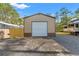 Metal garage with a roll-up door offering secure storage for vehicles and equipment on a gravel driveway at 9078 Birmingham Ave, Weeki Wachee, FL 34613