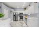 Well-equipped kitchen features white cabinets, stainless steel appliances, modern countertops, and sleek marble floors at 9078 Birmingham Ave, Weeki Wachee, FL 34613