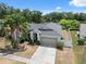 An aerial view showcases the home's manicured lawn, complemented by mature landscaping and a paved driveway at 9104 Water Hazard Dr, Hudson, FL 34667